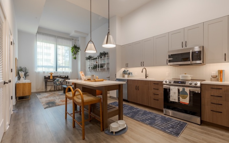 Model kitchen at our apartments for rent in Washington DC, featuring wood grain floor paneling and a kitchen island.