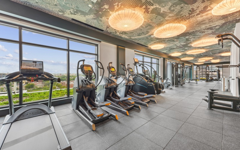 The fitness center at our apartments for rent in Washington DC, featuring treadmills, stair steppers, and spin bikes.