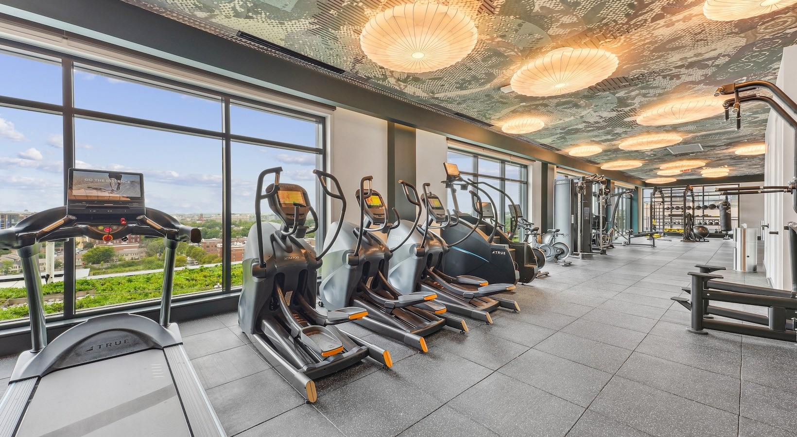 The fitness center at our apartments for rent in Washington DC, featuring treadmills, stair steppers, and spin bikes.